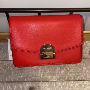 Brand new red Kate Spade bag with tags and strap.